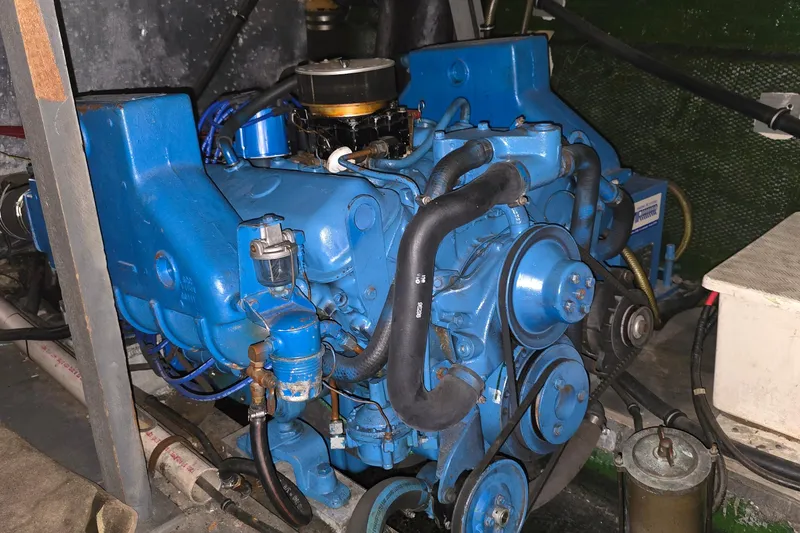 Slide: The Image of Engine of a 1979 Chris-Craft 410 Motor Yacht, painted blue, with visible belts and hoses. - 29