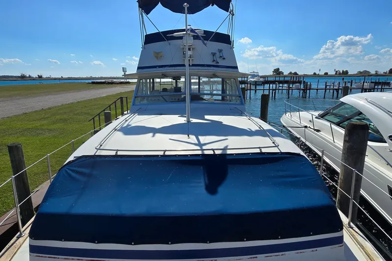 Slide: The Image of 1979 Chris-Craft 410 Motor Yacht docked by a scenic waterfront. - 5
