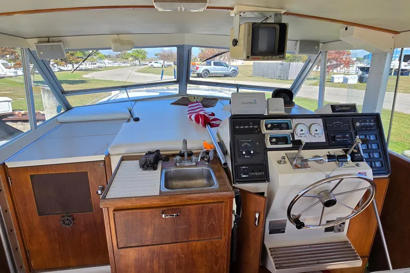 Slide: The Image of 1979 Chris-Craft 410 Motor Yacht helm with steering wheel, gauges, and sink. - 6