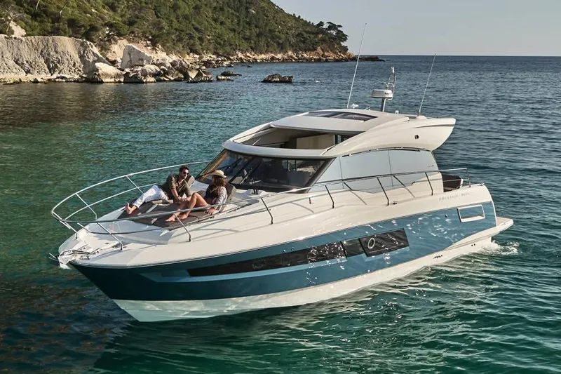 Slide: The Image of 2025 Prestige 460S yacht cruising on a scenic lake with lush greenery. - 4