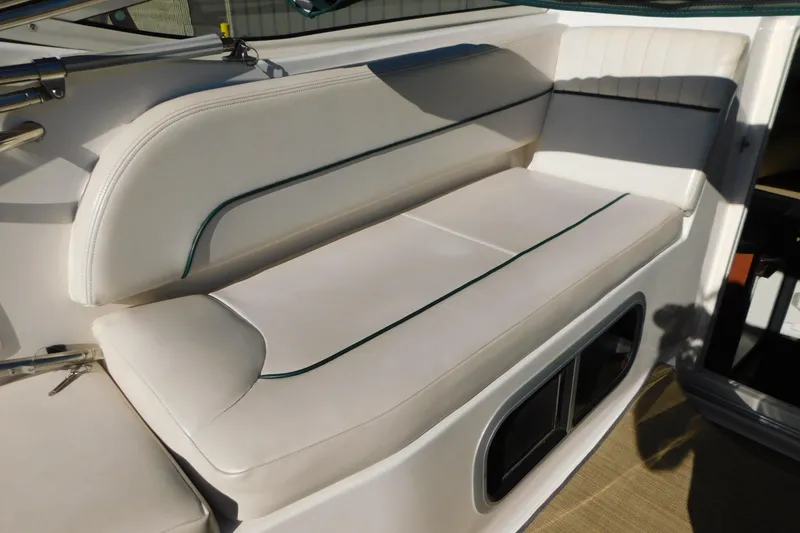 Slide: The Image of 2001 Chaparral Signature 240 boat interior seating with white upholstery and green accents. - 14