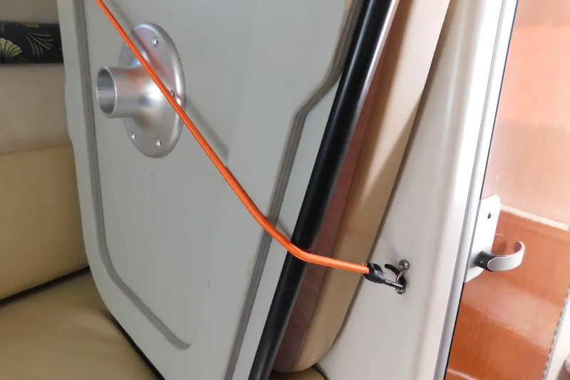 Slide: The Image of 2001 Chaparral Signature 240 cabin door with orange bungee cord securing it. - 25