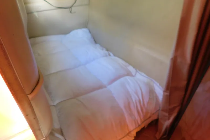 Slide: The Image of Interior cabin bed of 2001 Chaparral Signature 240 boat, featuring cozy bedding. - 29