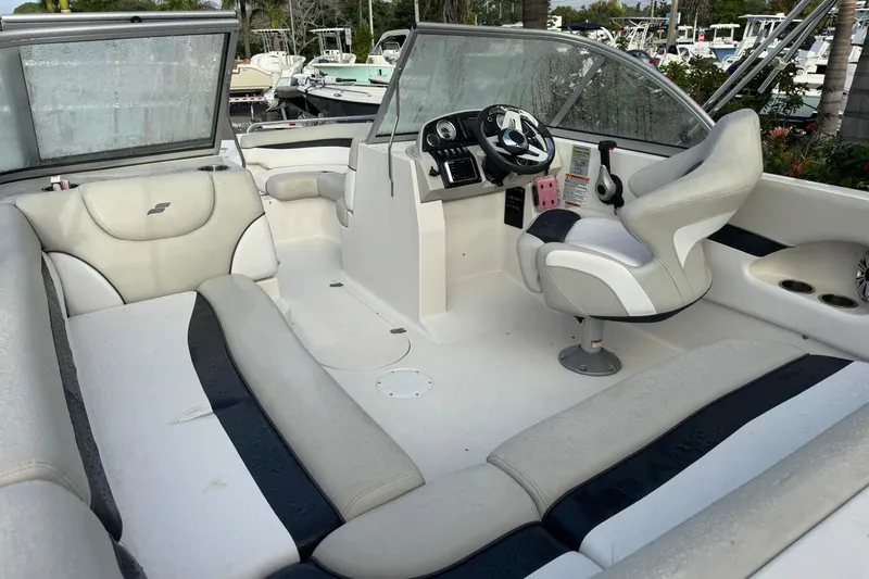 Slide: The Image of 2019 Starcraft MDX 210 OB boat interior with white seating and steering console. - 14