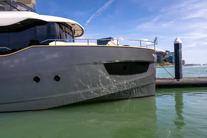 Slide: The Image of 2018 Absolute 58 Navetta yacht docked in a marina under clear blue skies. - 3