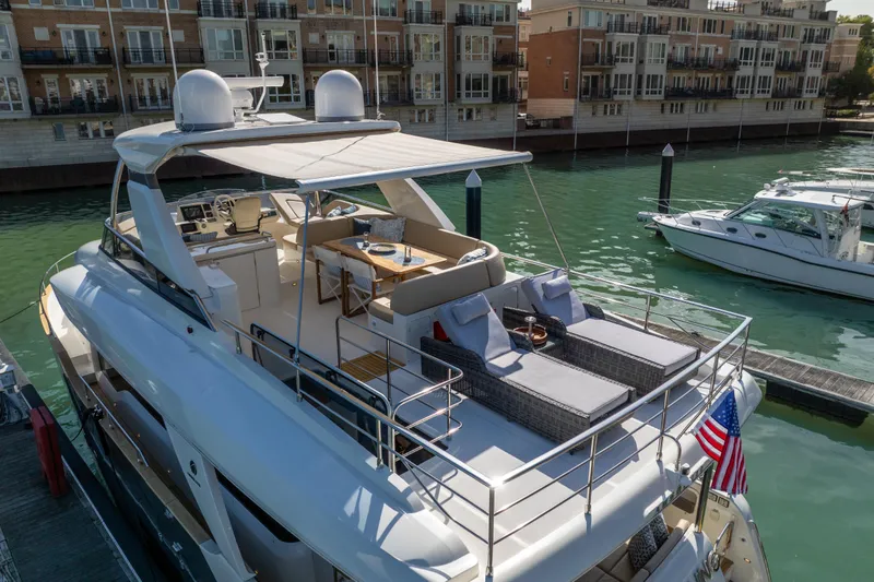 Slide: The Image of Luxurious 2018 Absolute 58 Navetta yacht docked, featuring spacious deck and elegant seating area. - 5