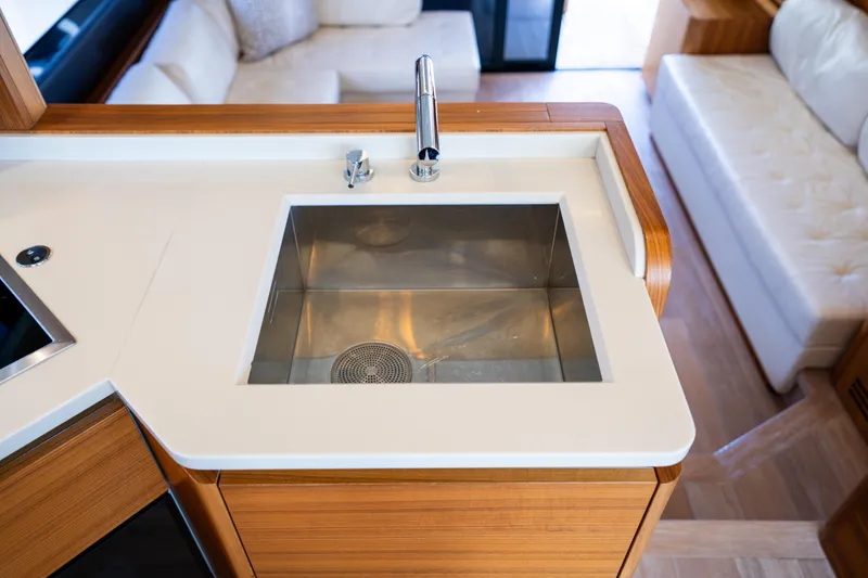 Slide: The Image of Modern kitchen sink on 2018 Absolute 58 Navetta yacht, featuring sleek design and wood accents. - 53