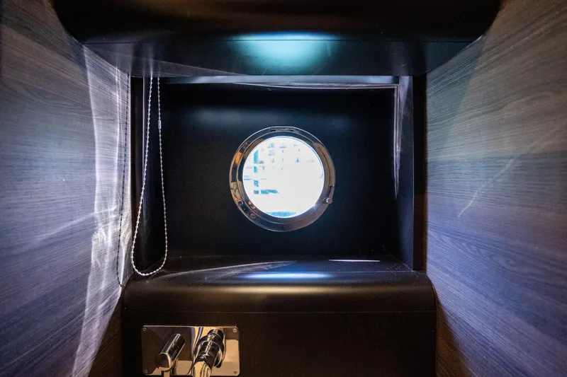 Slide: The Image of Porthole view inside 2018 Absolute 58 Navetta yacht, featuring sleek wooden interior design. - 69