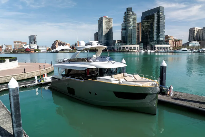 Slide: The Image of Luxury Absolute 58 Navetta yacht docked in urban marina, city skyline in background, 2018 model. - 9