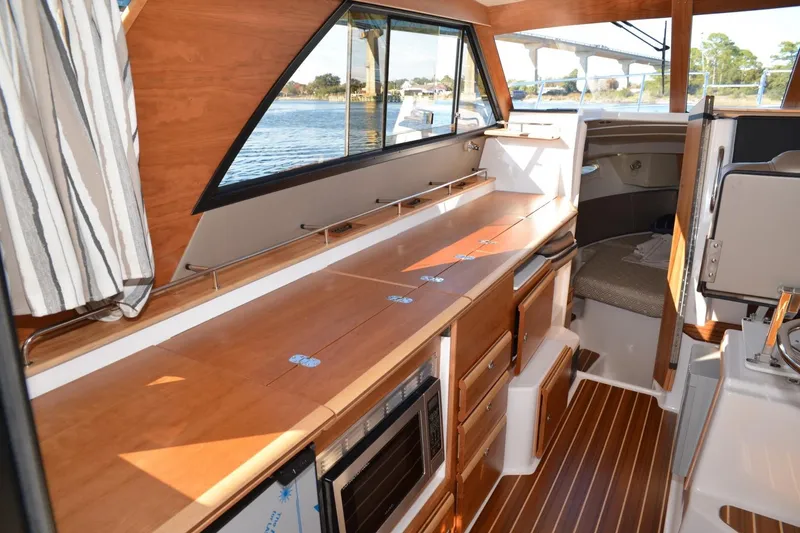 Slide: The Image of 2020 Cutwater C-30S interior with wood finish, kitchenette, and seating area. - 10
