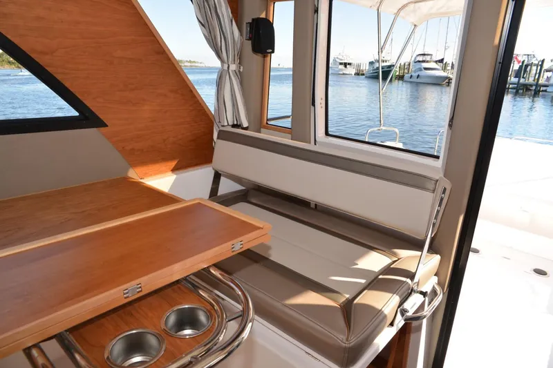 Slide: The Image of 2020 Cutwater C-30S interior with seating, table, and waterfront view. - 11