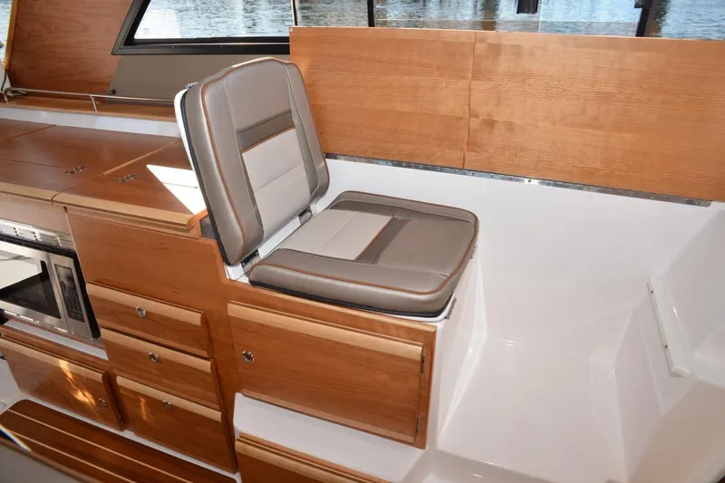 Slide: The Image of 2020 Cutwater C-30S interior with wood cabinetry and cushioned seating. - 13