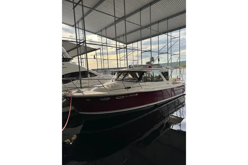 Slide: The Image of 2020 Cutwater C-30S boat docked in a covered marina, reflecting on water. - 2
