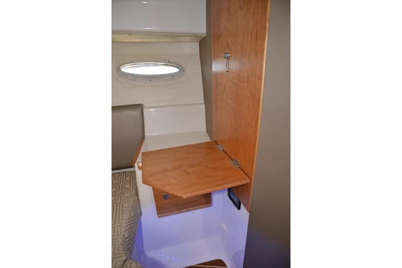 Slide: The Image of 2020 Cutwater C-30S interior with wooden fold-out table and porthole window. - 24