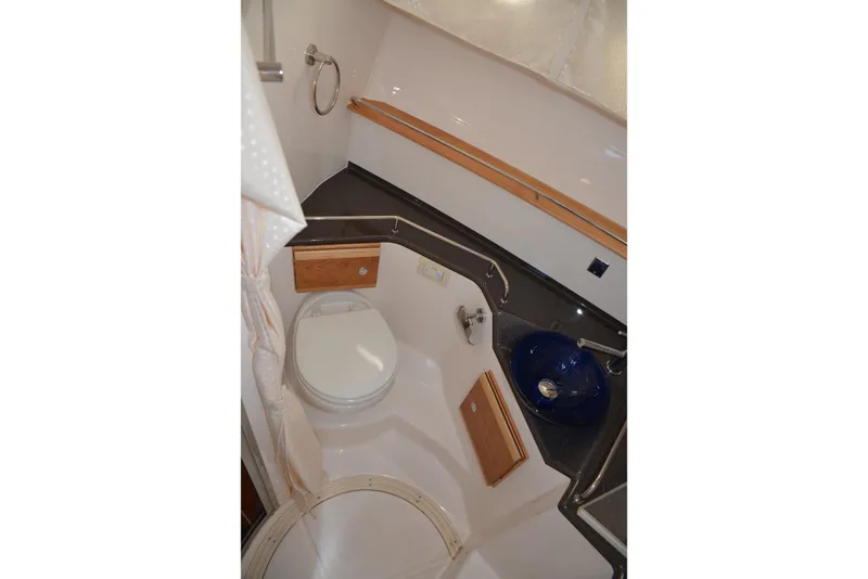 Slide: The Image of 2020 Cutwater C-30S boat bathroom with toilet, blue sink, and wooden accents. - 29