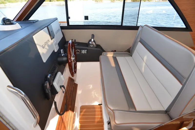 Slide: The Image of 2020 Cutwater C-30S boat interior with Garmin navigation, wooden steering wheel, and cushioned seating. - 7