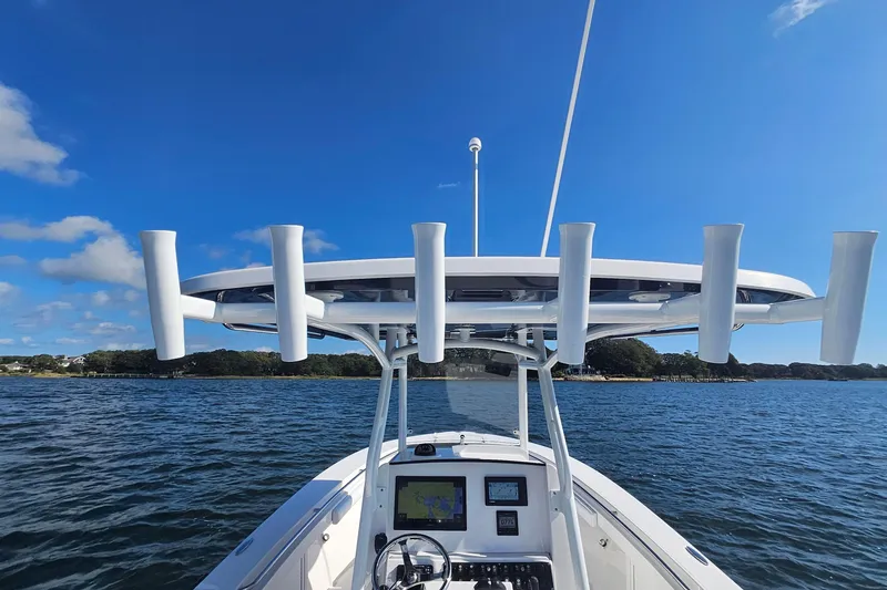 Slide: The Image of 2019 Southport 272 TE boat on water, clear sky, and shoreline in background. - 24