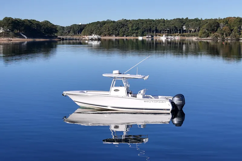 Slide: The Image of 2019 Southport 272 TE boat on calm water with forested shoreline background. - 9