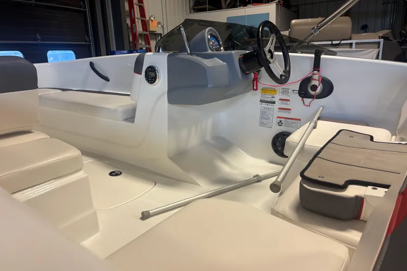Slide: The Image of 2020 Tahoe T16 boat interior with steering wheel and seating in a garage setting. - 12