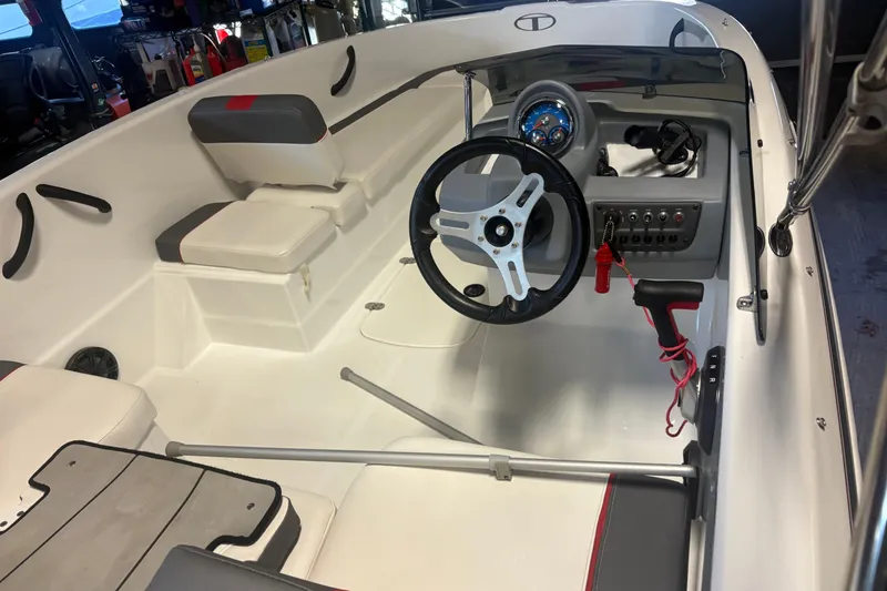 Slide: The Image of 2020 Tahoe T16 boat interior with steering wheel and seating in a showroom. - 15