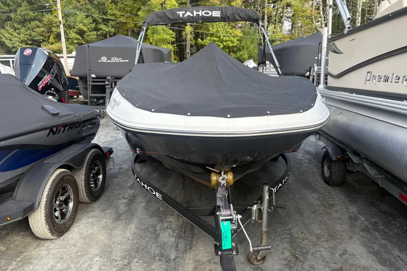 Slide: The Image of 2020 Tahoe T-16 boat with cover, parked on a trailer in a marina. - 6