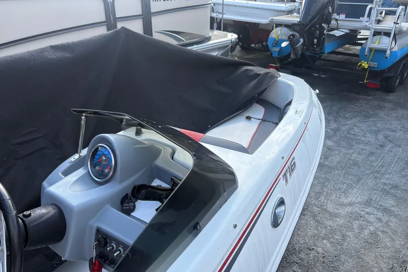 Slide: The Image of 2020 Tahoe T-16 boat with covered seating, parked near other boats. - 7