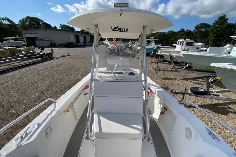 Slide: The Image of 2002 Mako 221 Center Console boat in a marina, surrounded by other boats. - 14