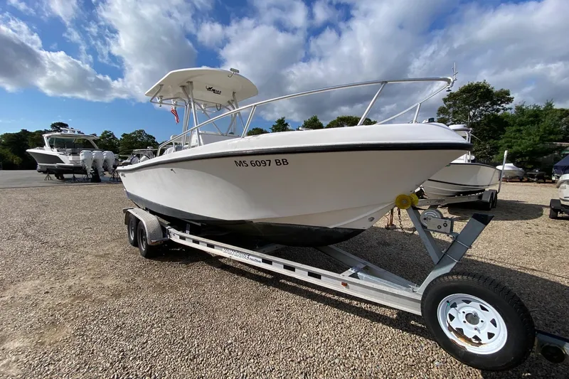 Slide: The Image of 2002 Mako 221 Center Console boat on trailer under a partly cloudy sky. - 7