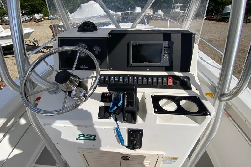 Slide: The Image of 2002 Mako 221 Center Console boat dashboard with steering wheel and navigation controls. - 8