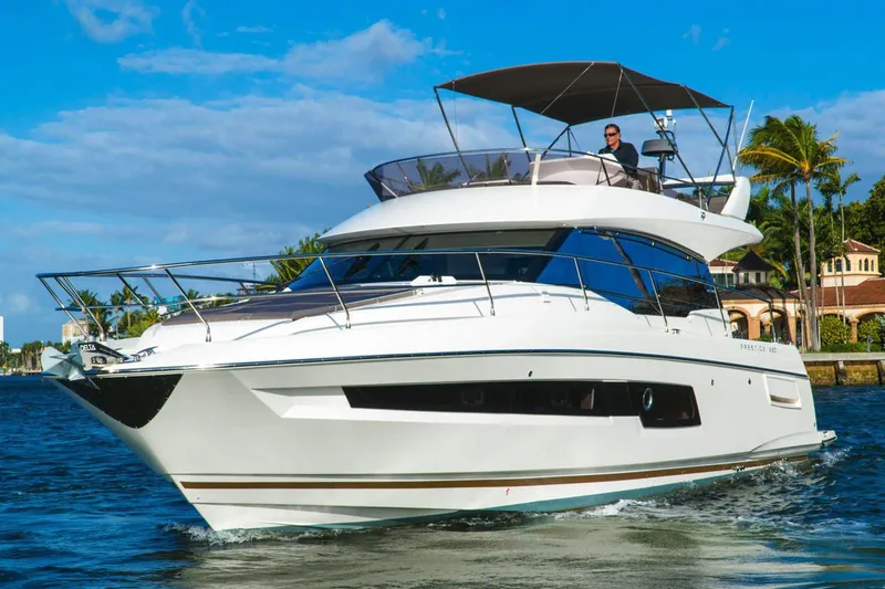 Slide: The Image of Luxury 2024 Prestige 460 yacht cruising near rocky cliffs under a blue sky. - 5