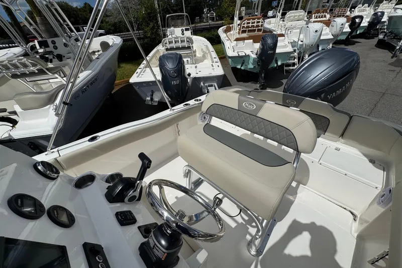 Slide: The Image of 2026 Key West 203 FS boat interior with steering wheel and seating, featuring Yamaha outboard motor. - 23
