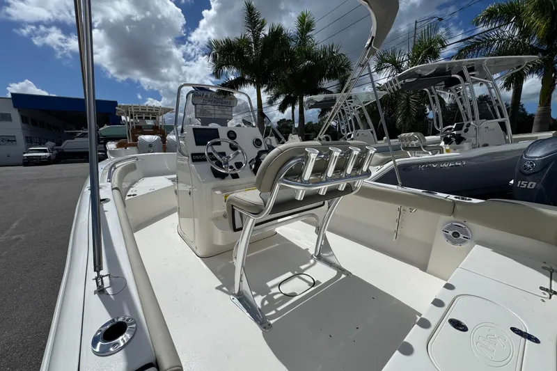 Slide: The Image of 2026 Key West 203 FS boat interior with steering console and seating, under a sunny sky. - 9
