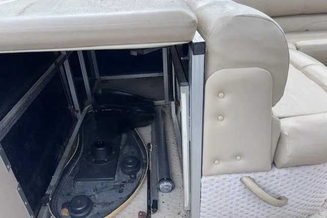 Slide: The Image of 2012 Tahoe Pontoon VT 2285 EL interior storage compartment with beige seating. - 17