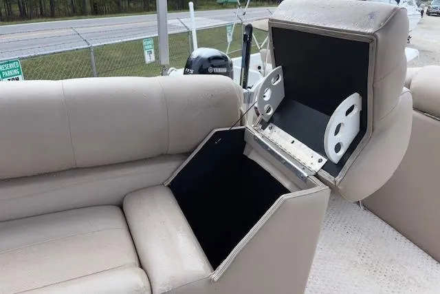 Slide: The Image of 2012 Tahoe Pontoon VT 2285 EL with open storage compartment on beige seating. - 23