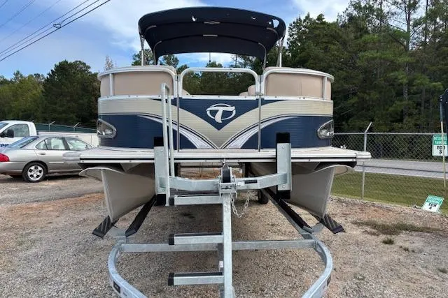 Slide: The Image of 2012 Tahoe Pontoon VT 2285 EL on trailer, parked outdoors near trees and a fence. - 3