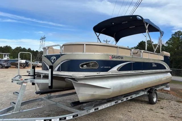 Slide: The Image of 2012 Tahoe Pontoon VT 2285 EL on trailer, blue and beige, parked outdoors. - 4