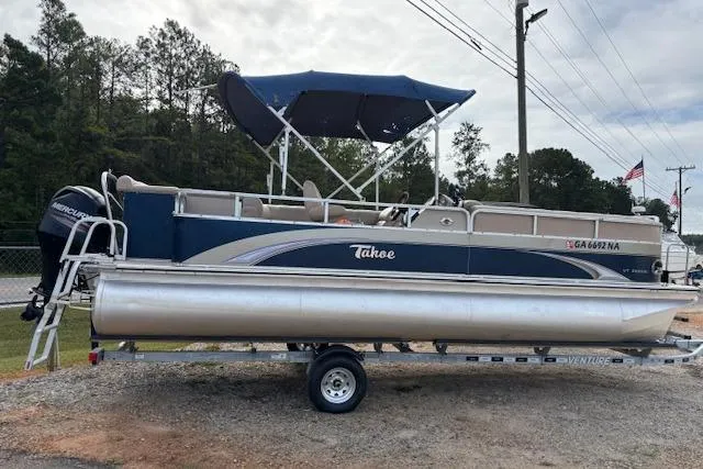 Slide: The Image of 2012 Tahoe Pontoon VT 2285 EL boat on trailer with canopy, parked outdoors. - 8
