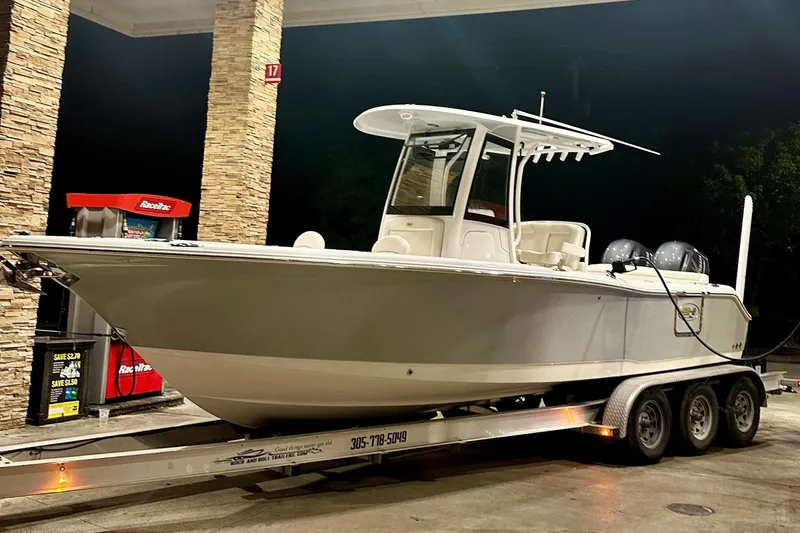 Slide: The Image of 2023 Sea Hunt Ultra 265 SE boat on trailer at gas station at night. - 10