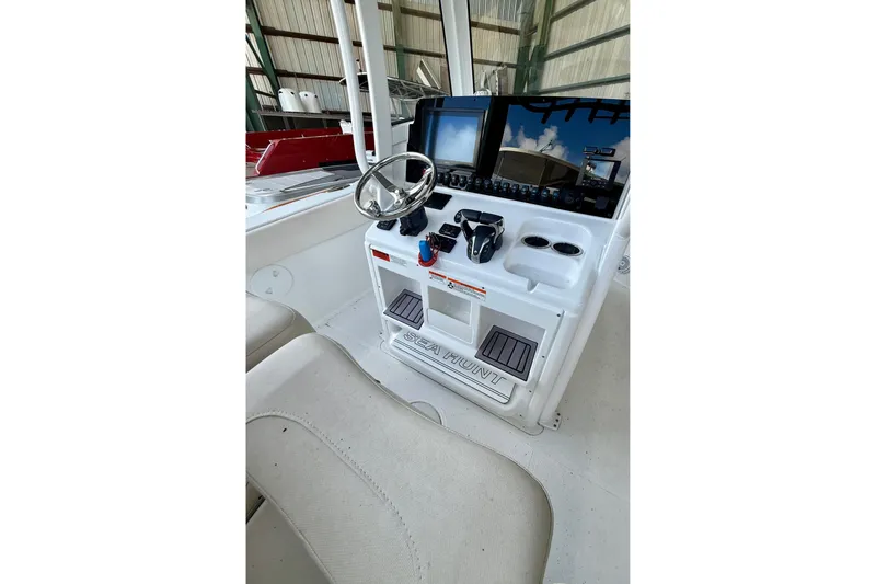 Slide: The Image of 2023 Sea Hunt Ultra 265 SE boat console with steering wheel and controls. - 13