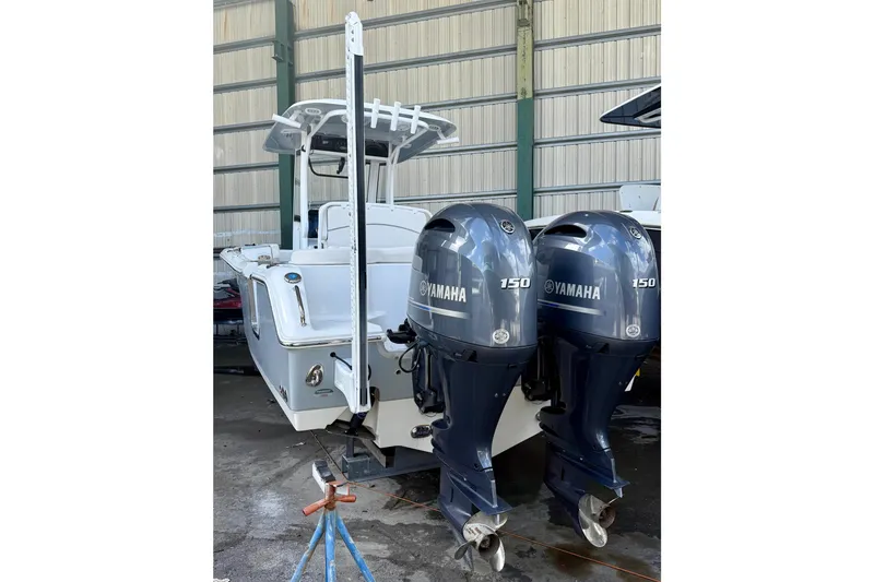 Slide: The Image of 2023 Sea Hunt Ultra 265 SE boat with dual Yamaha 150 engines in a storage facility. - 6