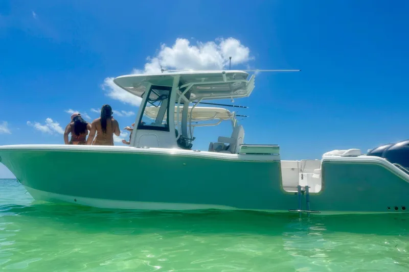 Slide: The Image of 2023 Sea Hunt Ultra 265 SE boat on clear turquoise water under blue sky. - 9