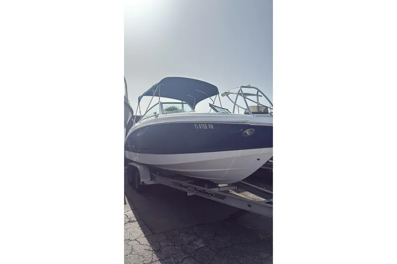 Slide: The Image of 2013 Chaparral Sunesta 224 boat on trailer, blue and white exterior, sunny day. - 3