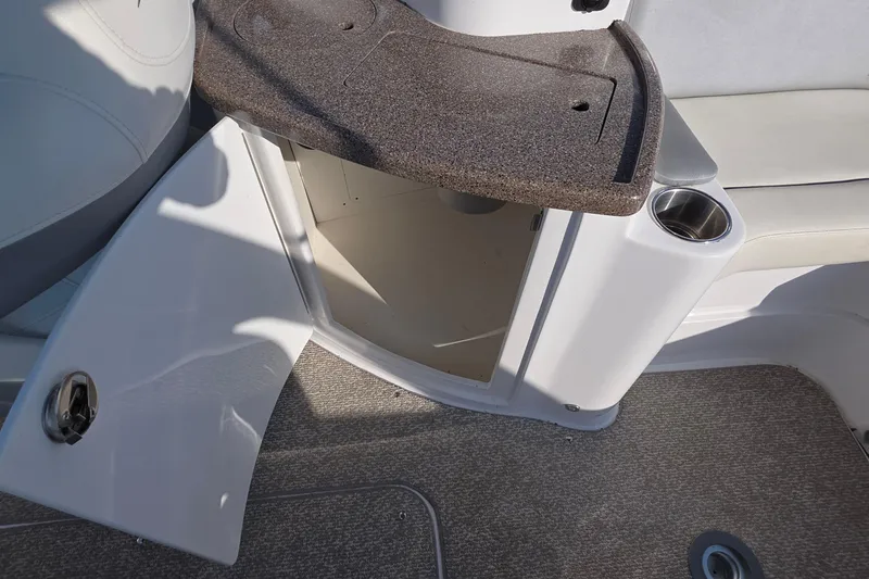 Slide: The Image of 2013 Rinker 276 Captina boat interior with open storage compartment and cup holder. - 27