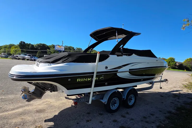 Slide: The Image of 2013 Rinker 276 Captina boat on trailer under clear blue sky. - 3