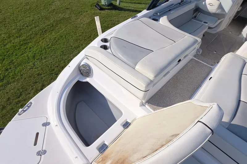 Slide: The Image of 2013 Rinker 276 Captina boat interior with open storage compartment and cushioned seating. - 30