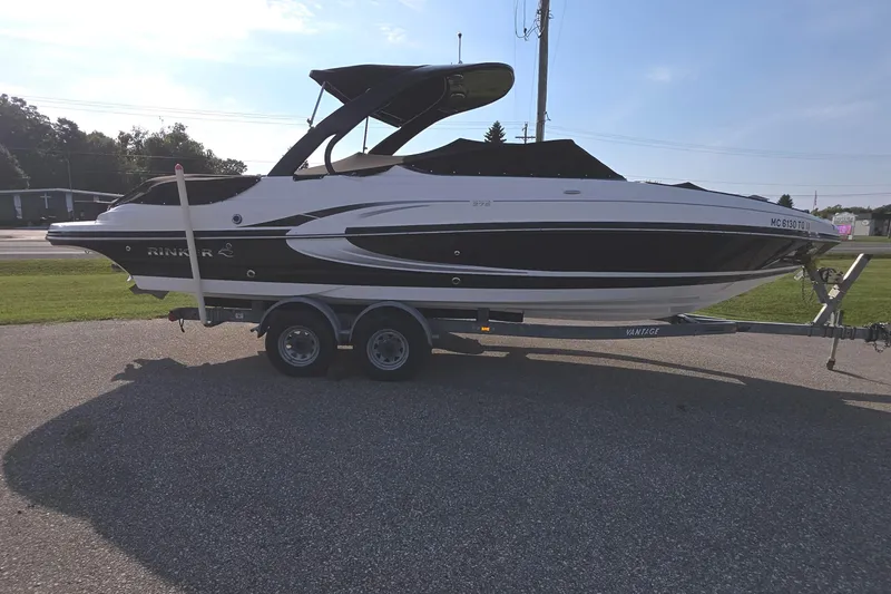 Slide: The Image of 2013 Rinker 276 Captina boat on trailer, parked outdoors on a sunny day. - 4