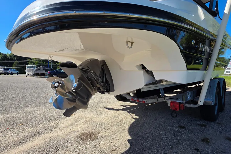 Slide: The Image of 2013 Rinker 276 Captina boat on trailer, showcasing propeller and hull design. - 7