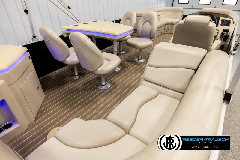 Slide: The Image of 2016 Bennington 24 SPDXDF boat interior with beige seating and wood-style flooring. - 12