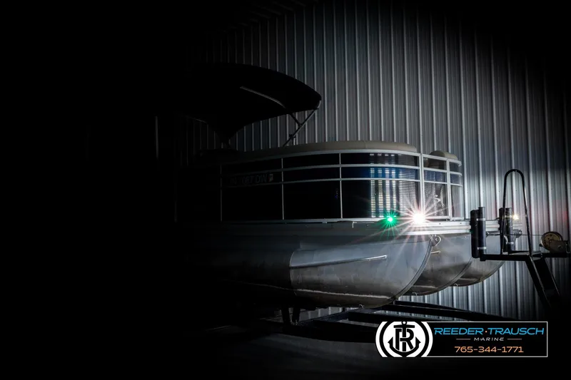 Slide: The Image of 2016 Bennington 24 SPDXDF pontoon boat in dimly lit storage facility. - 4