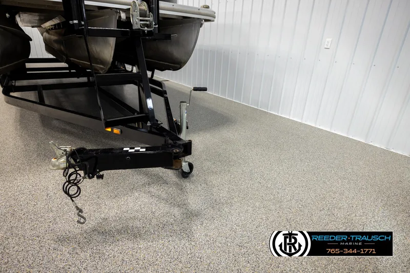 Slide: The Image of 2016 Bennington 24 SPDXDF boat trailer in a showroom with Reeder-Trausch Marine logo. - 53